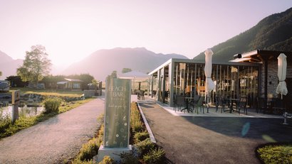 Sunny beach bar with terrace and mountain backdrop