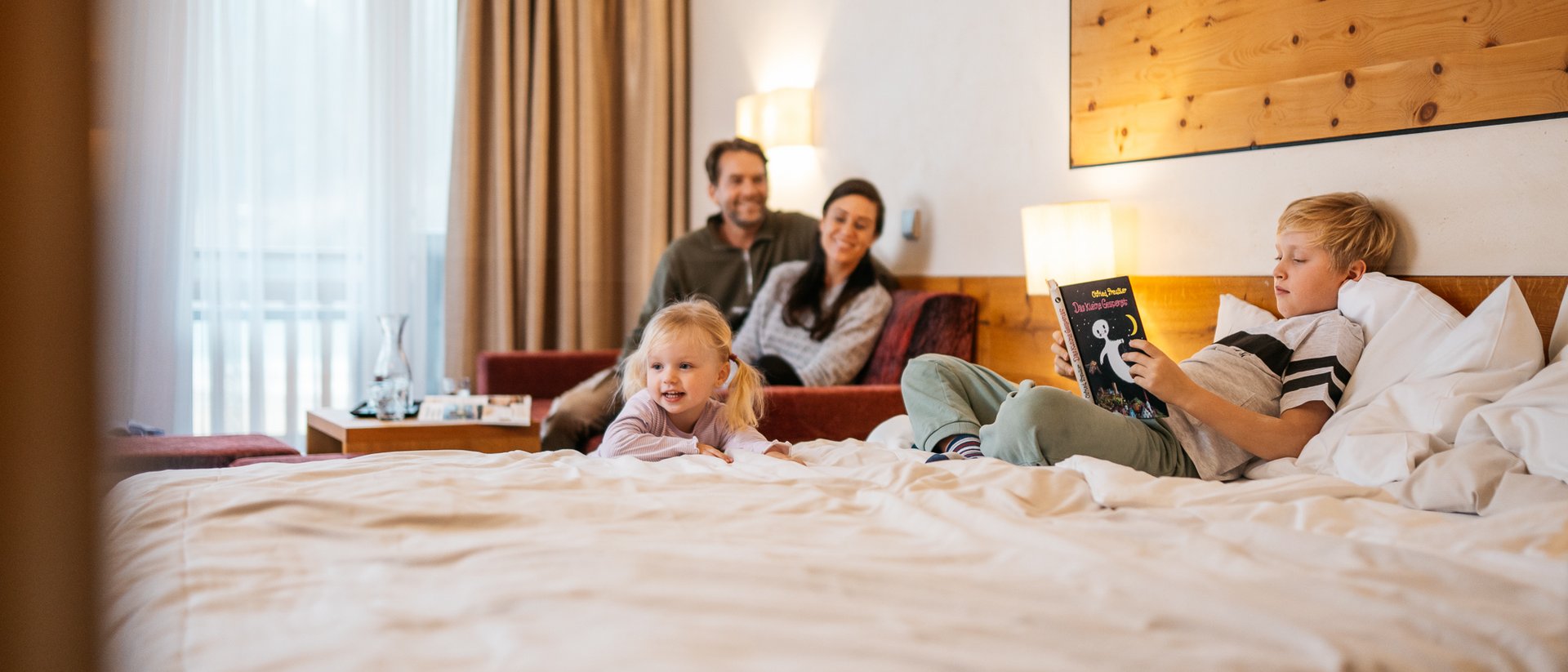 Active family holidays at Lake Achensee Family with two children relaxing in hotel room