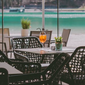 Pampering holidays with the little ones Empty outdoor café area with drink and lake view