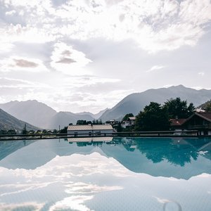 Berglandschaft spiegelt sich in klarem Wasser eines Pools