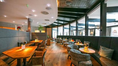 Modern seating area in a stylish café with wooden tables and cozy chairs.
