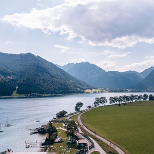 Blick auf See mit Segelbooten und Bergen im Hintergrund