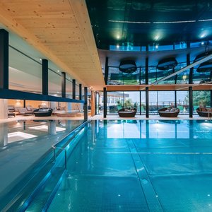 Moderner Innenpool mit Liegestühlen und Glasfront