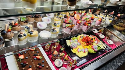 Display case with assorted desserts and fresh fruit