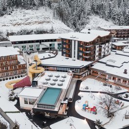 Hotel with water slide and snow in winter surrounded by forest