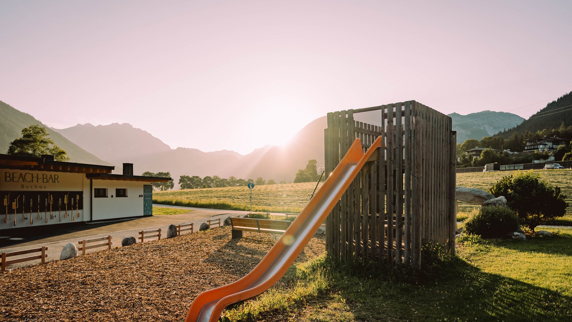Children's water slide in park at sunset with mountain view