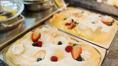 Fruit meringue desserts with strawberries, raspberries, and blueberries on trays